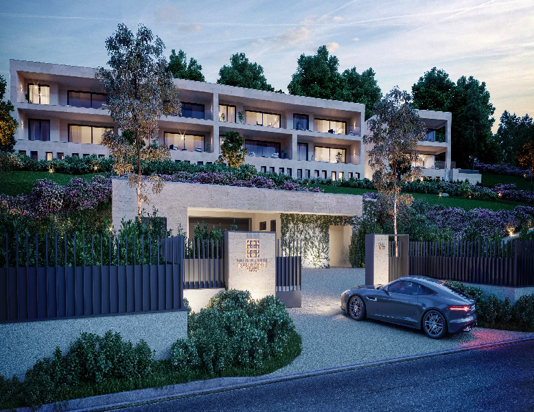 Outside of the new development project with a car entering the gated garden of this huge residence.