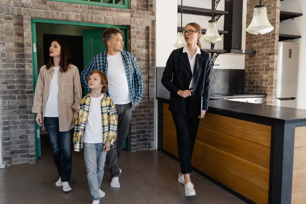 Real estate agent showing a house to a family.