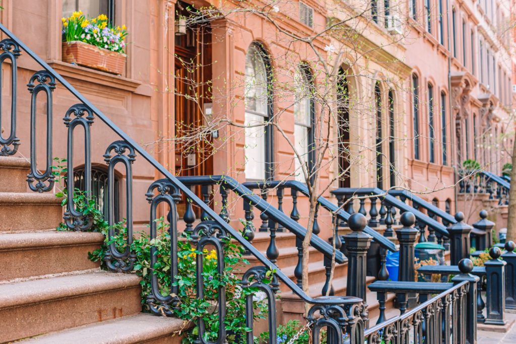 Brownstones with typical cast-iron stairs and flowers.